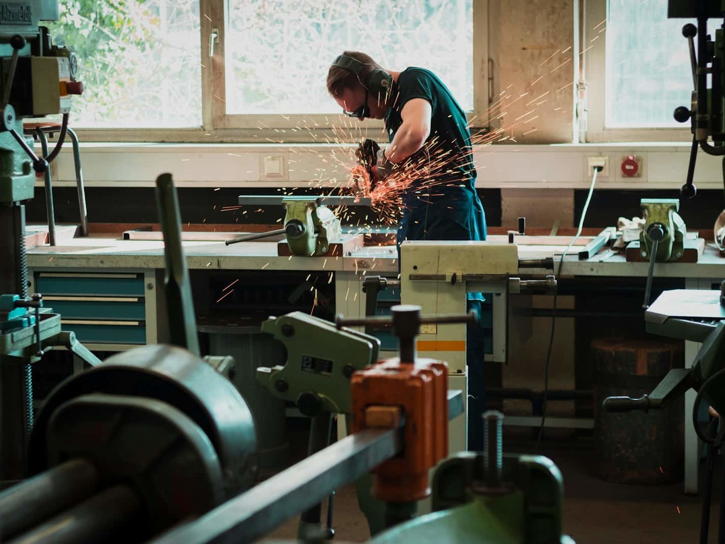 selective focus photography of man using angle grinder